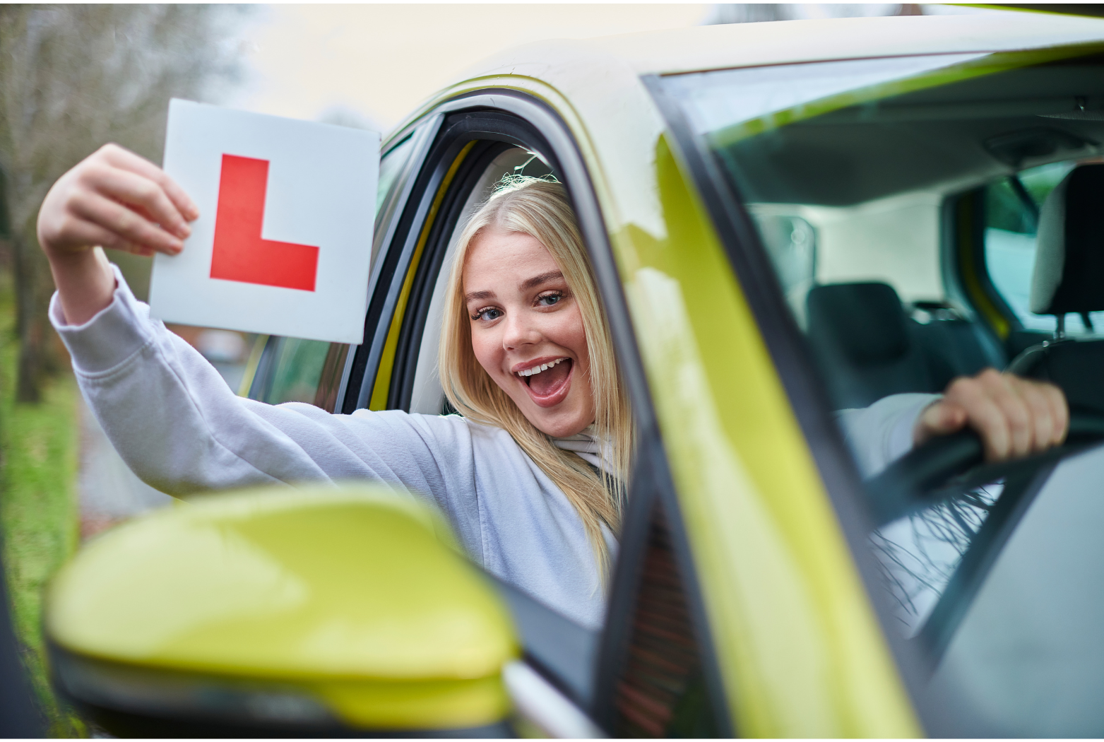 Successful driver with learner's plate after completing driving lessons